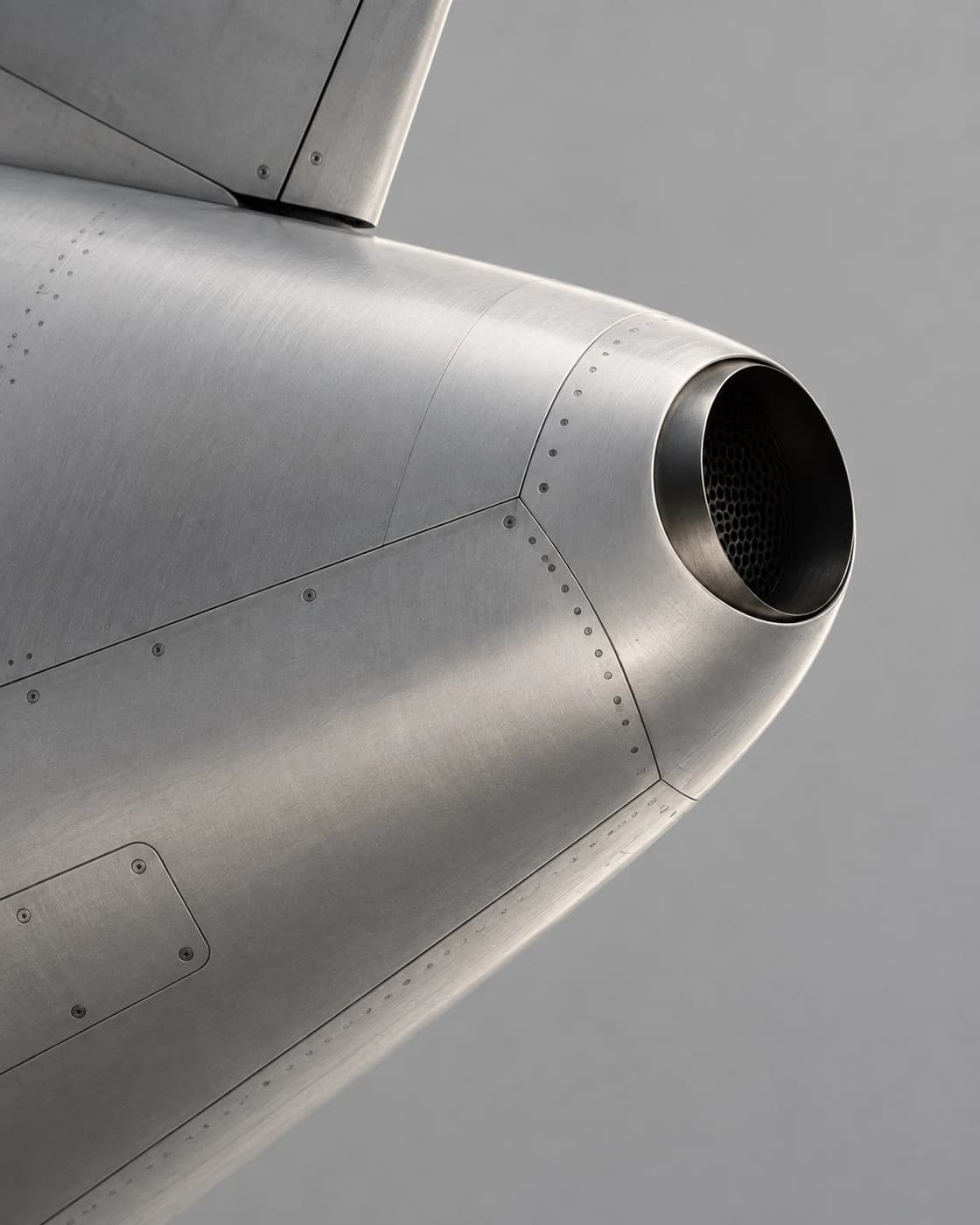 Brushed aluminum prototype detail with a recessed vent and quiet grey negative space.